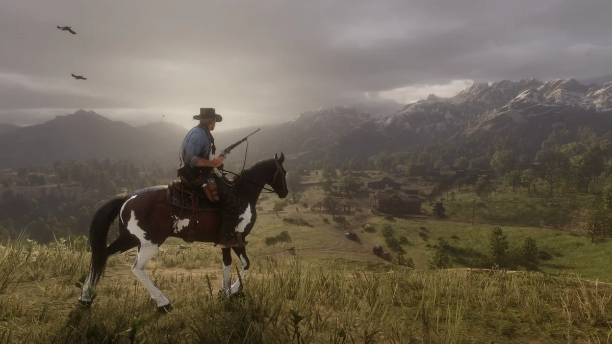 A lone rider overlooking Valentine beneath cloudy mountain skies